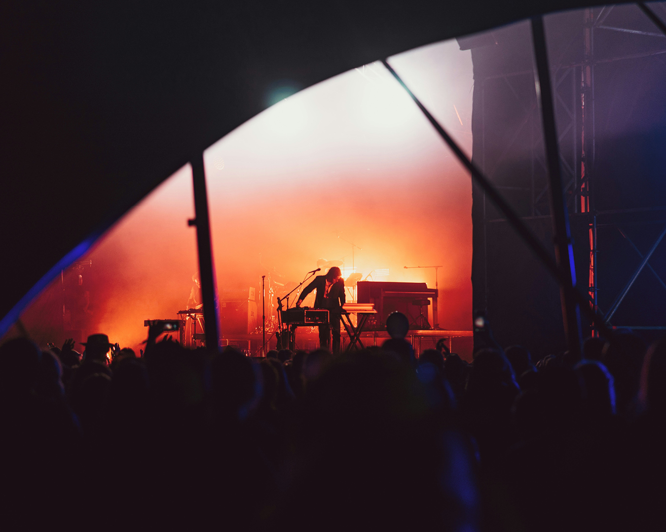 A crowd view of a performer at a music festival 