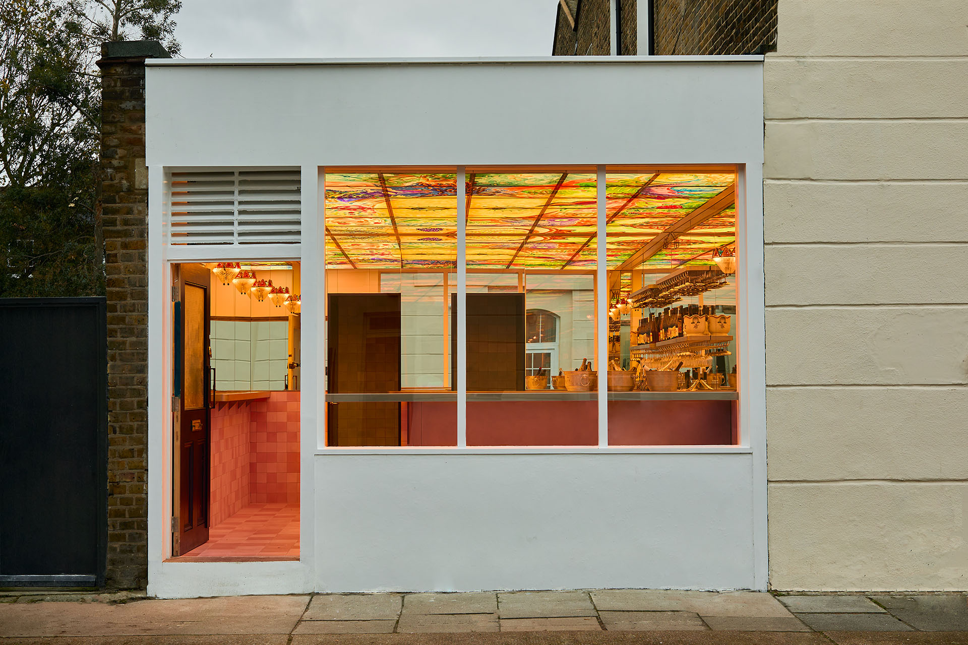 The exterior of The Dreamery, London, with a backlit mural in view.