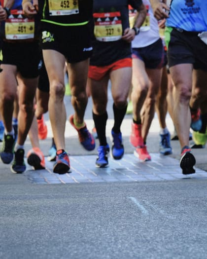 A detail of marathon runners running forward.