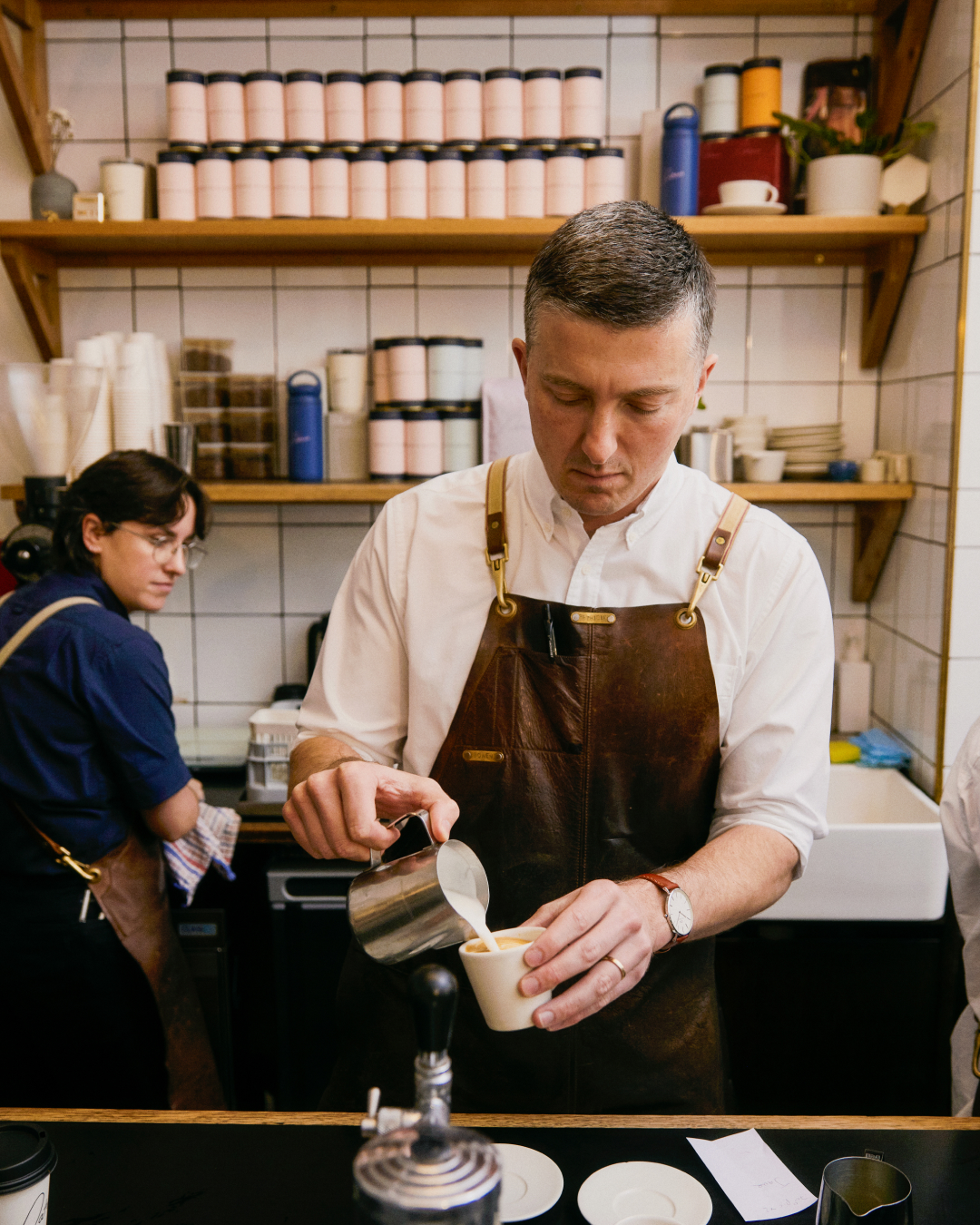 A barista pouring a flat white at Patricia Coffee Brewers. Photo by Ben Clement.