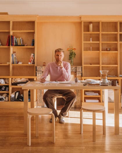 Jewellery designer Seb Brown sitting at his desk. Photography by Alex Cretey Systermans